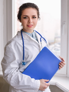 一位女大夫站在医院的文件夹图片