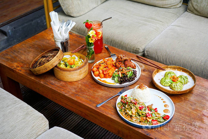 餐馆的一张木桌上摆着各式各样的菜肴法国菜中国菜上面有一个题字的