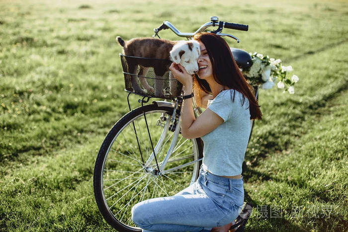 女孩在后面的自行车场里带着一只小狗走路.
