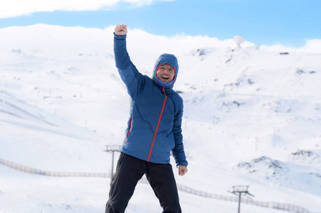 人，做着胜利的手势后高峰峰徒步成就在雪山上冬季景观