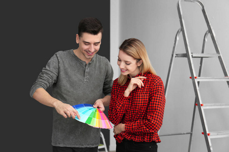 男设计师和年轻女子在空房间里为墙选择颜色