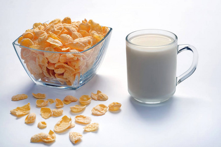 碗与玉米片和杯子与牛奶在轻的表面。健康食品
