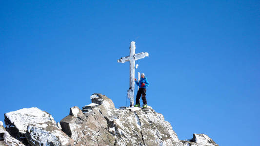 在一个美丽的冬日, 在高山山峰的顶峰交叉处, 男性的野外滑雪者