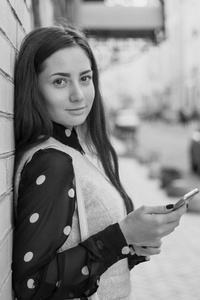 微笑的年轻女子与智能手机的肖像。黑色和白色
