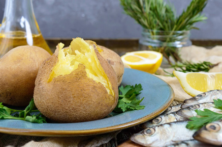 煮土豆在果皮.用盐鲱鱼的盘子上的热裂解马铃薯.膳食晚餐.