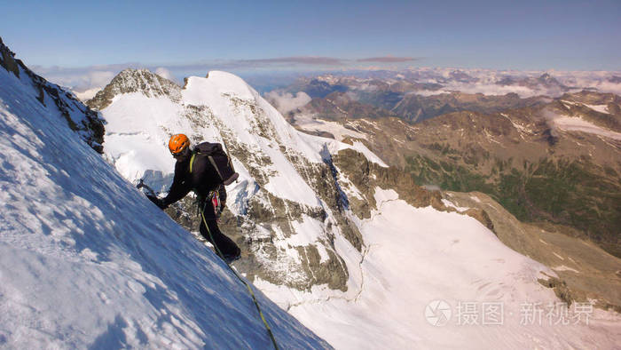 在高高山冰川上的雄性登山者, 在他身后的梦幻山景观的伟大景色