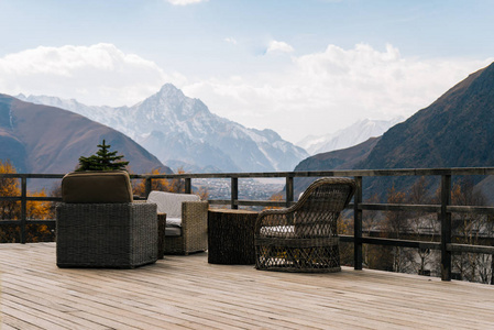 桌子山阳台上有一张桌子和一把椅子, 在蓝天下看到雄伟的山脉.照片