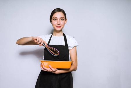 女孩厨师在黑围裙准备可口的食物, 蛋糕