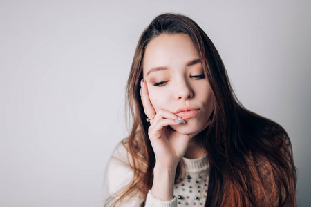 接近一个悲伤和沮丧的女人看着旁边。女孩低下头, 想在白色的背景上的东西