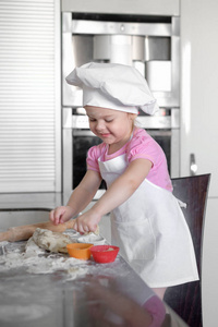 小女孩在厨房里做面团和曲奇饼
