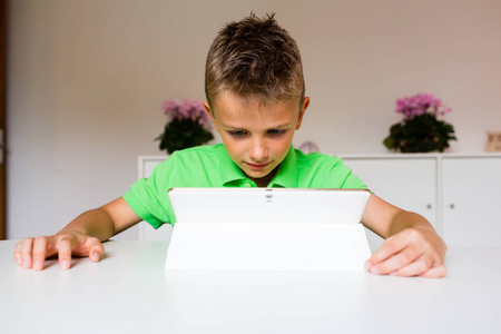 平板电脑的惊讶的孩子惊讶的男孩用白色平板电脑照片