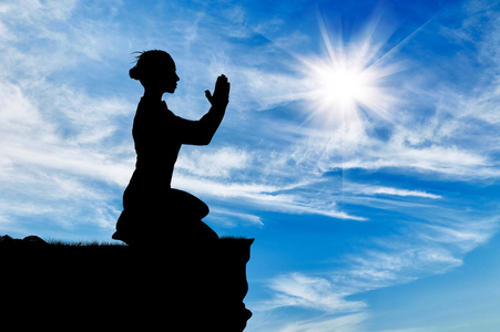 在我的膝盖上祈祷的女人的剪影照片