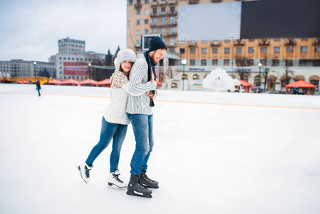 快乐的爱情侣拥抱在溜冰场, 冬天活跃休闲