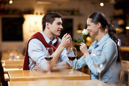 在咖啡馆庆祝情人节时, 两个快乐的年轻约会互相看着