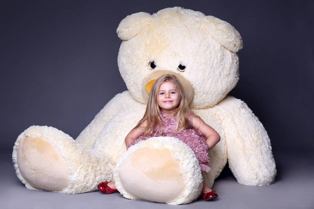 小女孩坐在大 teddys 腿上