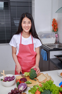 女用刀在厨房里切花椰菜