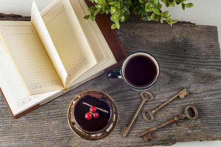 老式的旧书，杯茶 蛋糕和仿古木制的桌子上的钥匙