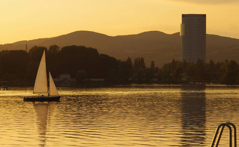 日落时在水面上的帆船。维也纳, 奥地利