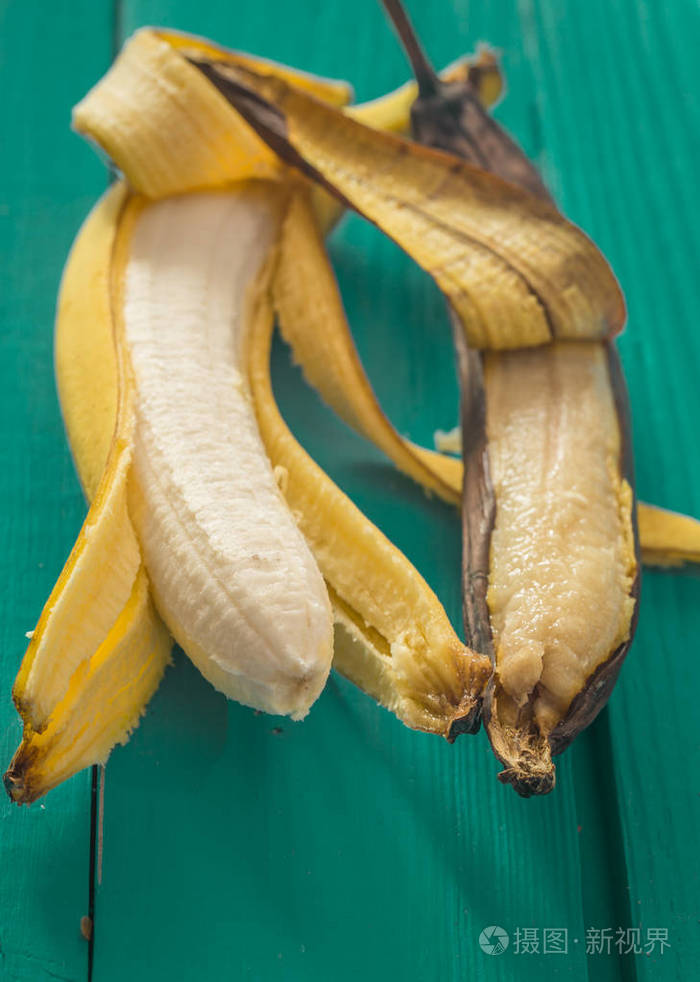 木制的背景上的新鲜和烂香蕉