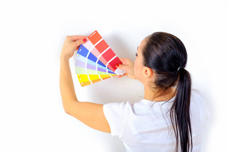 女孩画家选择油漆的颜色来修复房间