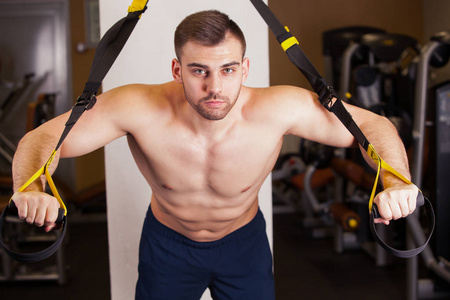 有吸引力的人做 Crossfit 在健身房工作室推 Ups 健身带