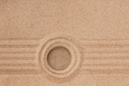 白色的石头位于一圈沙子的中心。暑期理念
