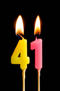 燃烧蜡烛的形式为41四十一 (数字, 日期) 的蛋糕孤立的黑色背景.