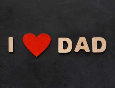 用木制字母写在黑色上的爱爸爸短语