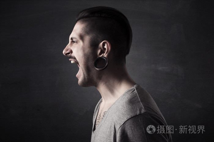 灰色背景上孤立的愤怒尖叫的人肖像