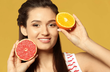 颜色背景的美丽的年轻妇女与柑橘果子