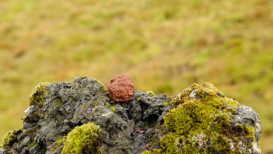石红色火山岩石与青苔图片