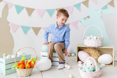 可爱的小男孩复活节彩蛋和兔子。复活节快乐。快乐有趣的男孩玩复活节兔子