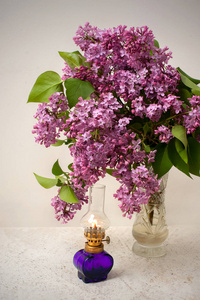 水晶花瓶和一盏煤气灯的丁香花浪漫花束