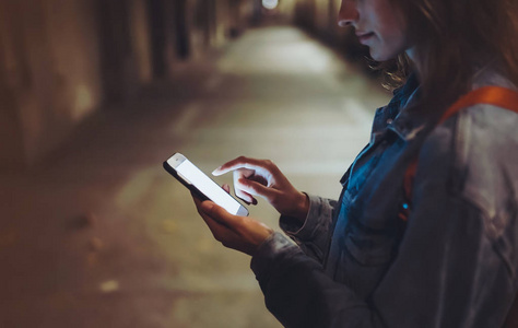 巴塞罗那的街道女人指着屏幕上的智能手机背景照明散灯在夜间大气