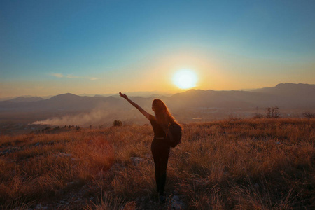 日落山。旅游自由快乐的女人伸出双臂机智