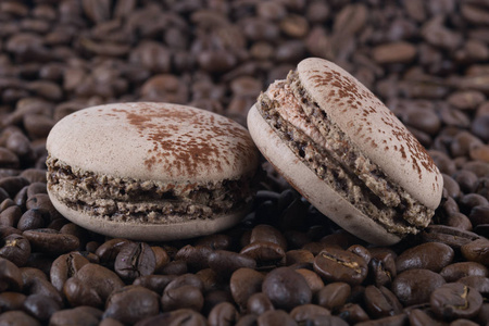 两个饼干咖啡蛋白甜饼饼干躺在咖啡豆的背景上