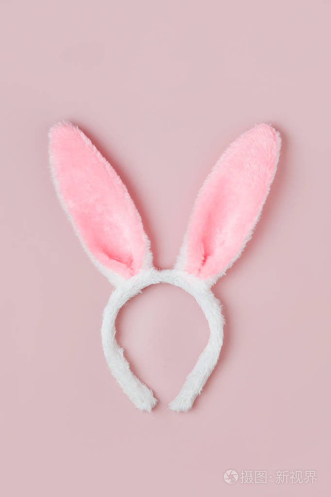 可爱的兔子耳朵在苍白的粉红色背景复活节概念