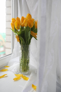 窗台上的花瓶里有一束黄色的郁金香。礼物 t