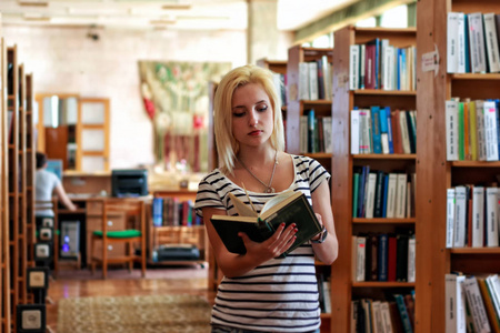 学习年轻十几岁的学生的女大学生中有书籍的图书馆