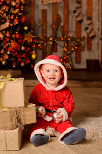 笑婴儿装扮成圣诞老人圣诞节背景散景新年灯