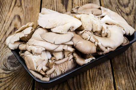 新鲜牡蛎蘑菇在黑包裹