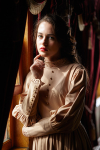 20 世纪初站米色复古服饰的年轻女子