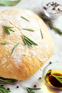 新鲜的 ciabatta 面包与迷迭香和额外的橄榄油在乡村白色背景