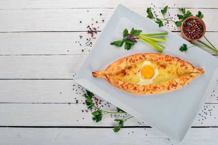 Khachapuri 鸡蛋和奶酪。格鲁吉亚菜。顶部视图。在一个木质的背景。复制空间