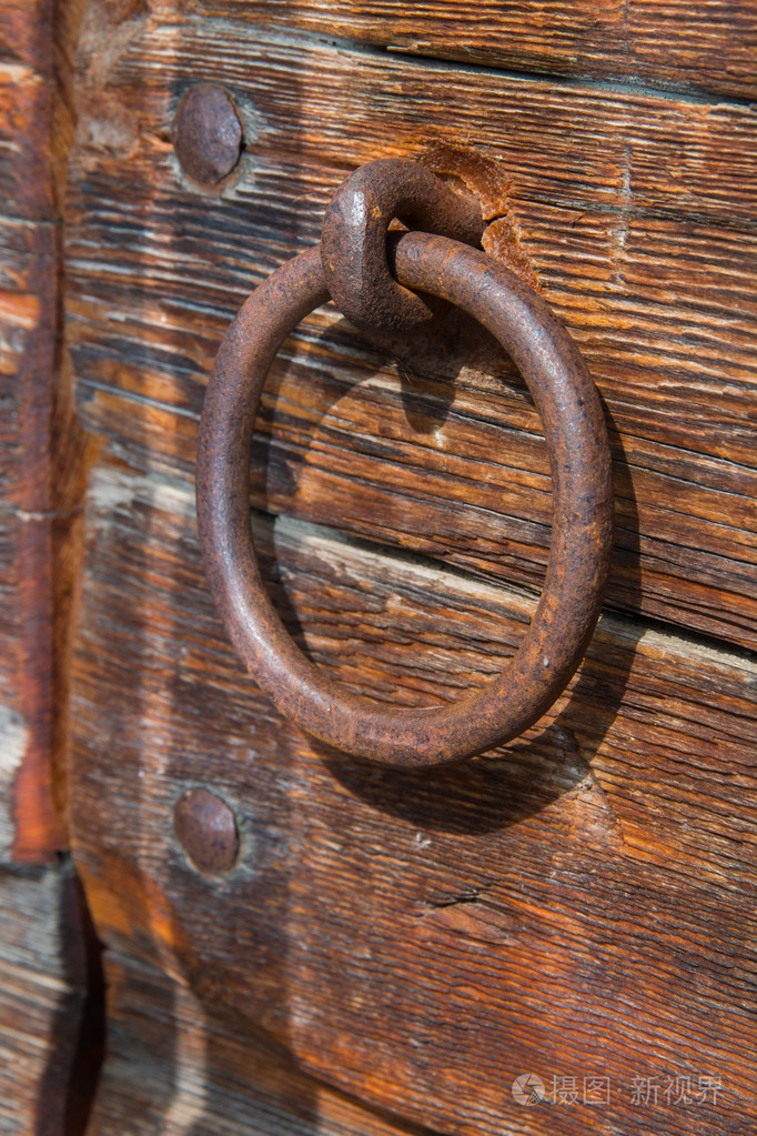 旧生锈的门把手上一扇木门