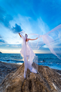 年轻的新娘，在日落时在海边