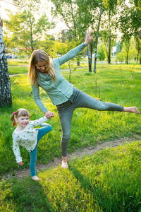 快乐的年轻妈妈和她的小女儿在公园里玩得很开心。