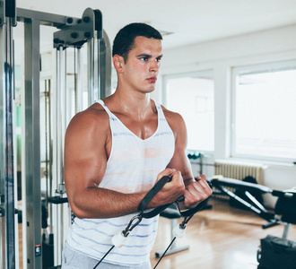 年轻有魅力的成年男子锻炼和做举重在健身馆。室内运动训练
