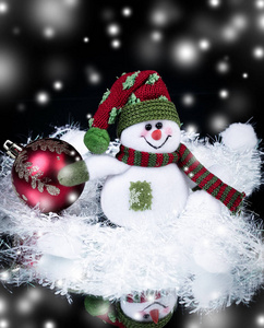 有趣的玩具雪人和圣诞球的黑色背景