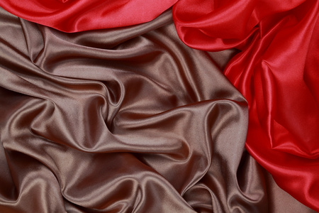 棕色和红色丝缎布的波浪褶皱纹理背景